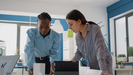 Close up of multi ethnic people working with blueprints plan to design architectural building. Women...