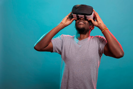 African american person using vr goggles and looking up to see 3d visual simulation, in front of...