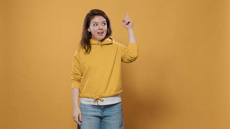 Portrait of smiling woman having an idea thinking being spontaneous touching temples with index...