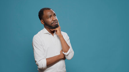 Pensive young adult brainstorming ideas to find solution, taking thoughts into consideration and thinking about answer. Uncertain person contemplating about serious problem, pondering decision.の写真素材