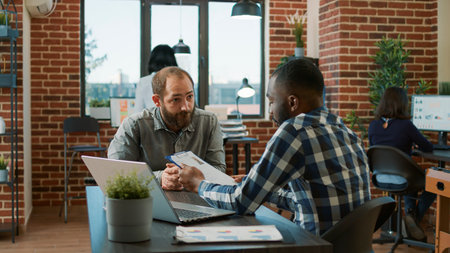 Diverse group of men attending job interview to discuss hiring and information about career recruitment. Candidate and employee having conversation about application at meeting.の写真素材
