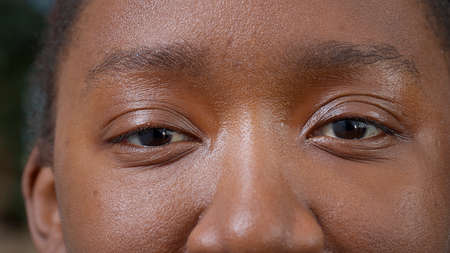 Macro shot of natural woman looking at camera, opening and closing eyes with brown color. Female person blinking and showing retina, pupil, eyeball and eyelashes, having healthy vision. Close up.の写真素材