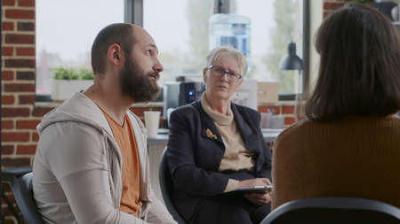 Man in despair sharing sad story about alcohol addiction in front of people at aa group therapy....