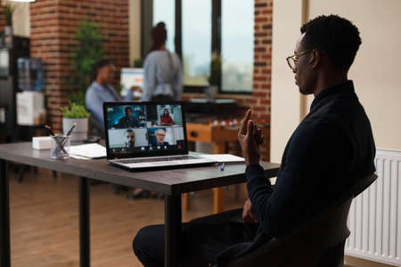 Businessman discussing through videocall with employees about marketing strategy of startup project. Marketing company financial team brainstorming business funding ideas while on digital meeting.の写真素材