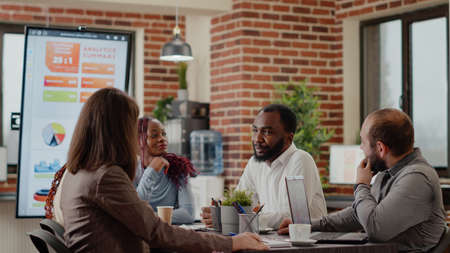 Business people arriving together in meeting office, talking about project planning and startegy. Colleagues working on company growth and development, using data analysis and statistics.の写真素材