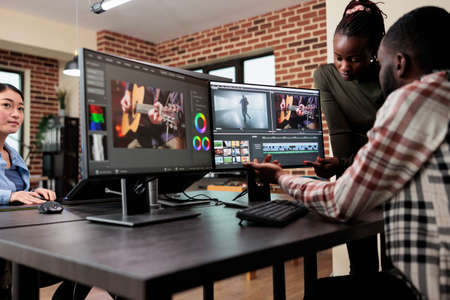 African american professional video editors enhancing digital footage using specialized software....