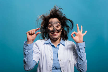 Mad wacky scientist with glass microscope slide looking confused after dangerous lab explosion....