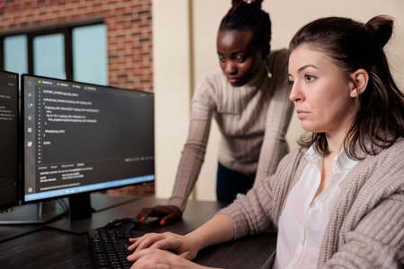 Informational agency multiracial tech engineers programming application while using computer. Cyber security company developers encrypting cloud processing data system using blockchain technology.の写真素材