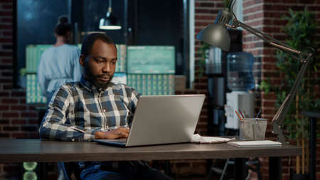 Sales trader working on stock market economy with laptop, developing hedge fund exchange and forex...