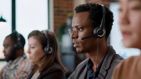 African american worker having conversation on headset with client, offering telemarketing...