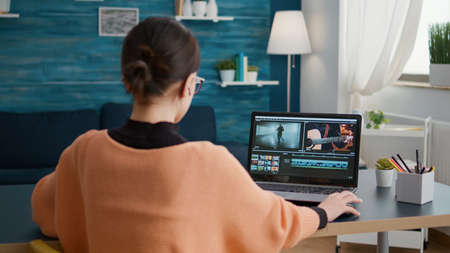 Female colorist working on video footage design with multimedia software, using movie content for...