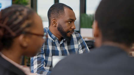 Business man talking to colleagues at boardroom meeting, doing teamwork to create financial strategy...