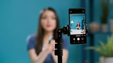 Content creator recording lifestyle vlog on filming camera, doing makeup tutorial for channel...