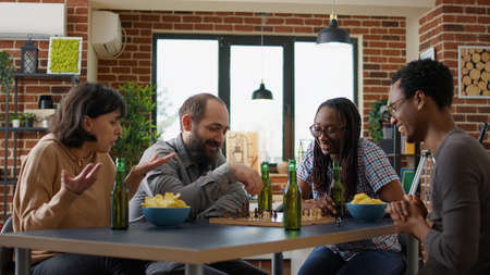 Multiethnic group of people having fun with chess game, playing match on chessboard. Cheerful...