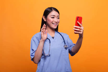 Healthcare clinic nurse wearing medical instrument waving at teleconference videochat call....