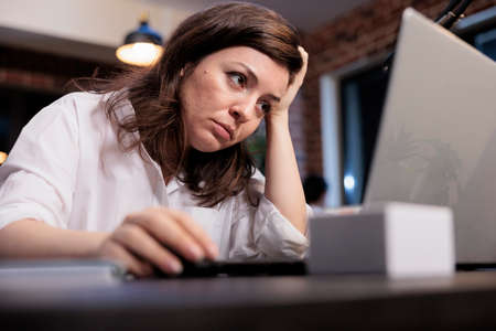 Tired business company employee sitting at desk in office workspace while suffering from fatigue...