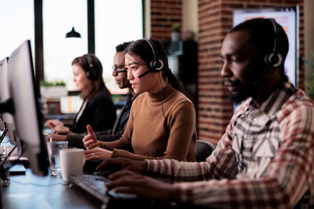 Telemarketing assistant working at customer service helpdesk, talking to clients on helpline support...