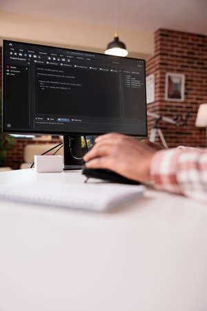 Selective focus on computer screen of african american programmer working remote from home...