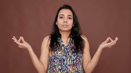 Healthy woman meditating in front of camera with yoga pose, feeling zen about meditation concept. Using concentration to meditate for mindfulness and peaceful energy, positive peace.の写真素材