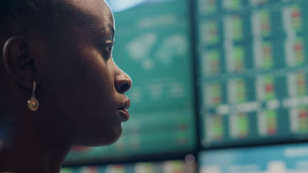 Hedge fund trader analyzing real time stocks on monitors, looking at financial exchange statistics in office. Forex trade market to obtain profit and price numbers. Close up. Handheld shot.の写真素材