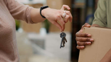 Married couple buying first home and having house keys, moving in real estate property together. Celebrating relationship event and household relocation bought on mortgage. Close up.の写真素材
