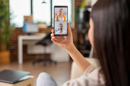 Authentic busy asian woman on video call meeting online communication workign from home. talking...