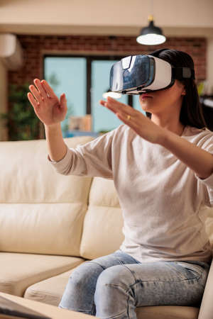 Happy asian woman enjoying wearing VR virtual reality headset, modern glasses technology headset future device gadget digital entertainment game simulationの写真素材