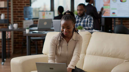African american worker analyzing business charts and financial statistics on laptop to plan...