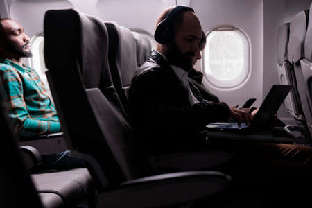 Multiethnic group of travellers sitting in airplane seats to fly abroad, travelling to business trip...