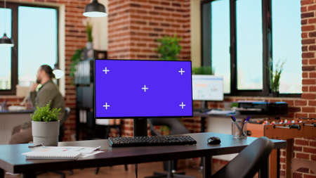 Empty office desk with greenscreen display on computer desktop, isolated chroma key background with...