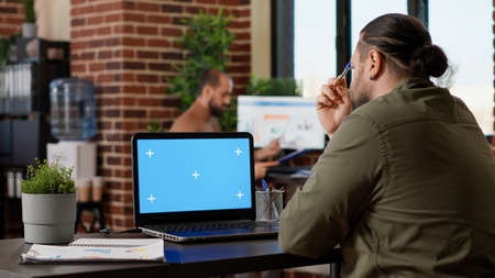 Pensive employee brainstorming ideas and using greenscreen on laptop, working on business report...
