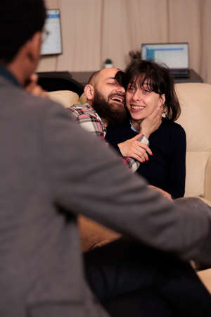 Smiling man and woman hugging and celebrating reconciliation at therapy session, feeling cheerful...