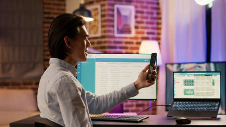 Asian businessman talking on online videocall meeting with people, using webcam and smartphone app....