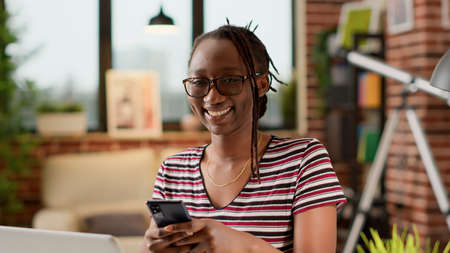Portrait of businesswoman texting messages on mobile phone, using social media app on remote work...