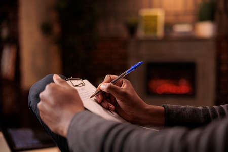 Professional counselor taking notes on paper at couple therapy, writing marriage issues and behaviour to give psychotherapy advice and solution. Psychology support and help. Close up.の写真素材