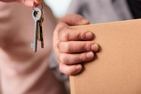 Young couple holding keys of household property to move in and start new beginnings together....