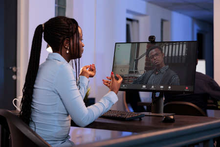 Female freelancer using online videocall conference on computer to talk to manager about startup...