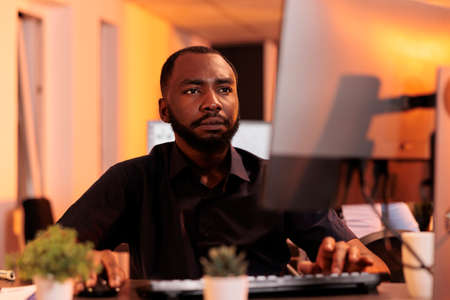 Confident businessman analyzing data charts on computer, doing research to create project report...