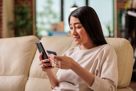 Asian woman buying online doing shopping using credit card on phone, smartphone credit happy female pay internet web purchase payment money customer asia app paymentの写真素材