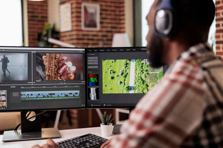 Graphic designer editing footage on software, working to edit video montage with color grading and...