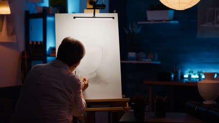 Old woman with creative skills drawing professional artwork with vase inspiration and artistic...