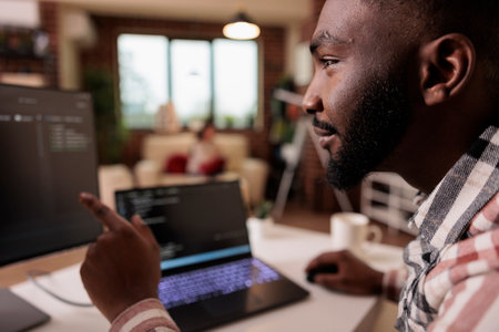 African american it engineer programming binary code interface, using css html script and encryption on computer. Male freelancer coding security server with software developer application.の写真素材