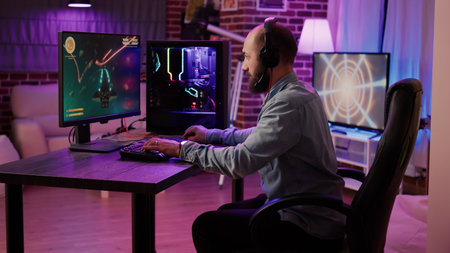 Gamer playing fast paced space shooter simulation screaming victorious at the computer screen after...