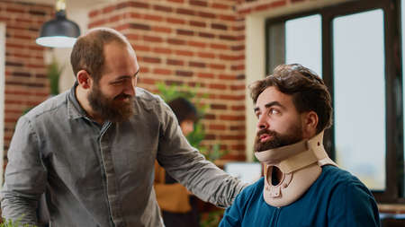 Office employee with neck collar brace working after accident injury, being in pain at job. Injured...