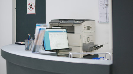 Hospital reception counter with medical appointments on computer to help patients with healthcare insurance. Empty registration desk used to give support and fill in checkup papers.の写真素材