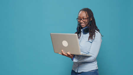 African american person browsing internet on laptop, using computer to scroll through social media...