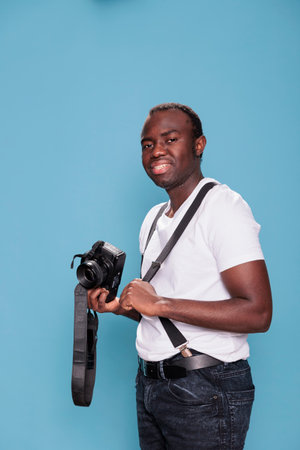 Confident and handsome looking young adult person wearing trendy clothes while having photo device....