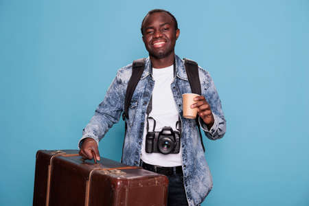 Happy photographer having luggage and DSLR camera getting ready for holiday journey. Joyful photography enthusiast with photo device and baggage going on weekend voyage trip.の写真素材
