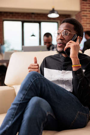 Corporate manager using smartphone call line to talk to people about office paperwork and online...