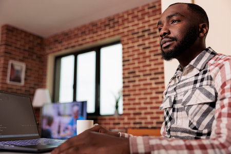 Programmer writing program code and html data base on new user interface. Male freelancer using...